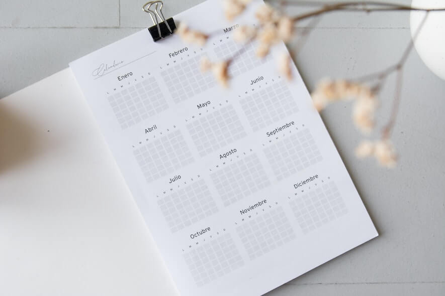 A white yearlong calendar sits on a white table